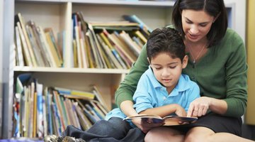 Teacher reading with student in library.