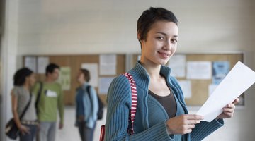 A smiling student holding a paper.