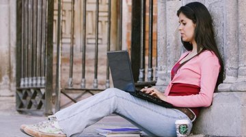 Student studying on laptop on campus.