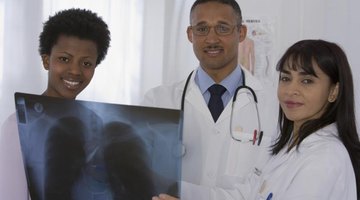 Group of doctors looking at an X-ray of lungs.