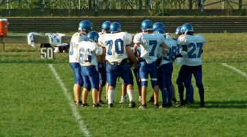 A group of football players practice on a field.