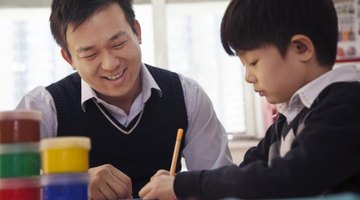 Teacher working with student at desk.