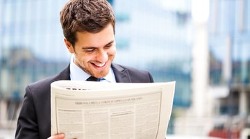 Man reading newspaper article.
