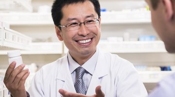 Pharmacist holding up prescription.