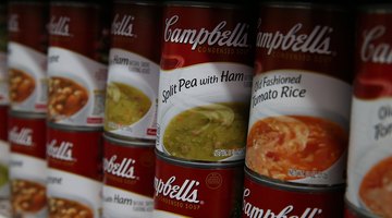 Close-up of a variety of Campbell's Soup cans on a shelf.