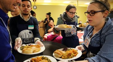 Volunteers serving meals at a homeless shelter.