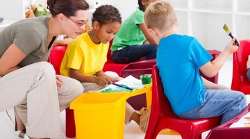 A kindergarten teacher works with her students in a classroom
