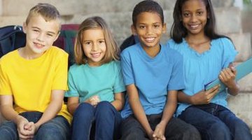 Group of diverse children from different backgrounds sitting together on cement steps