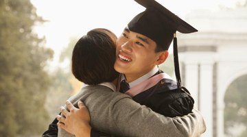Smiling young graduate hugging his mother.