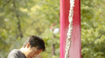 A father and son pray at a Shinto shrine in Japan.