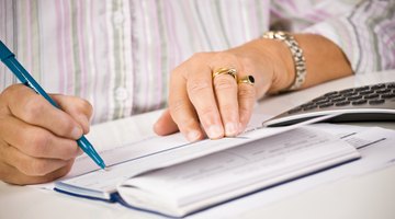 Close-up of woman writing a check