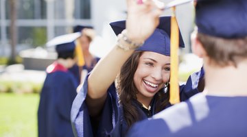 A young woman adjusts her friend's cap at a commencements ceremony.
