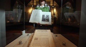 The head of collections at Durham University Library holding a book from the Shakespeare exhibit.
