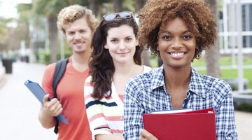 Three students smiling on college campus
