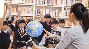 Excited children look at a world globe