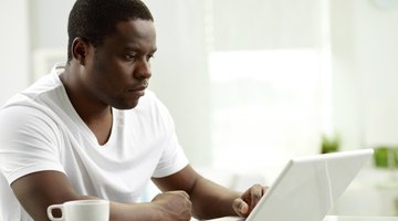 Student typing essay up at home on laptop