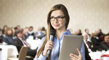 Student holding microphone and tablet about to give speech