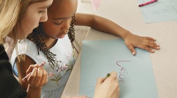Teacher working with student at table.