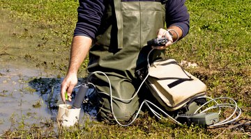 A wildlife biologist conducting water measurements.