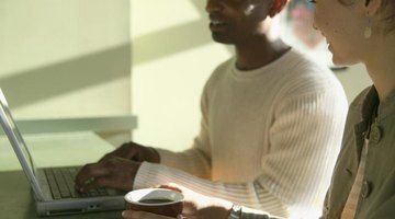 Two people are using a laptop together.