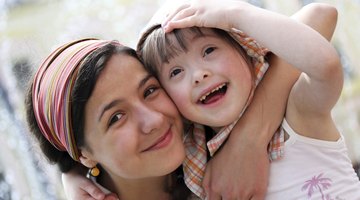 Young woman hugging girl with special needs