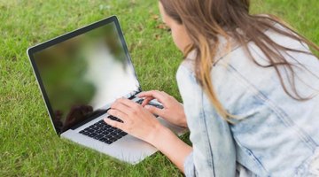 A college aged student is working on her laptop.