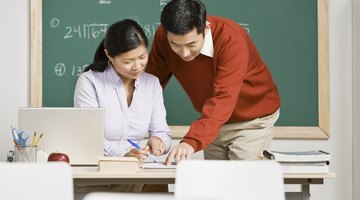 Student showing teacher paperwork at her desk
