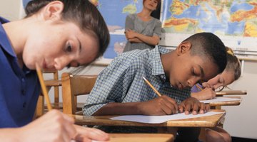 Students taking tests at desks in classroom