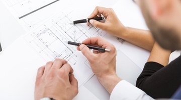 Close-up of two architecture students drawing on draft paper