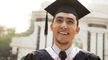 Smiling graduate in cap and gown.